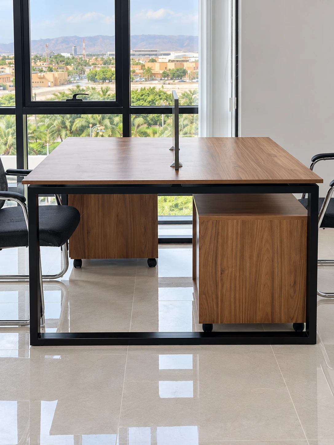 Two-person office workstation with black steel frame and mobile drawer units in Salalah